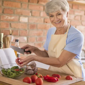 Mamie Julia préparant une salade maison avec des légumes frais dans sa cuisine